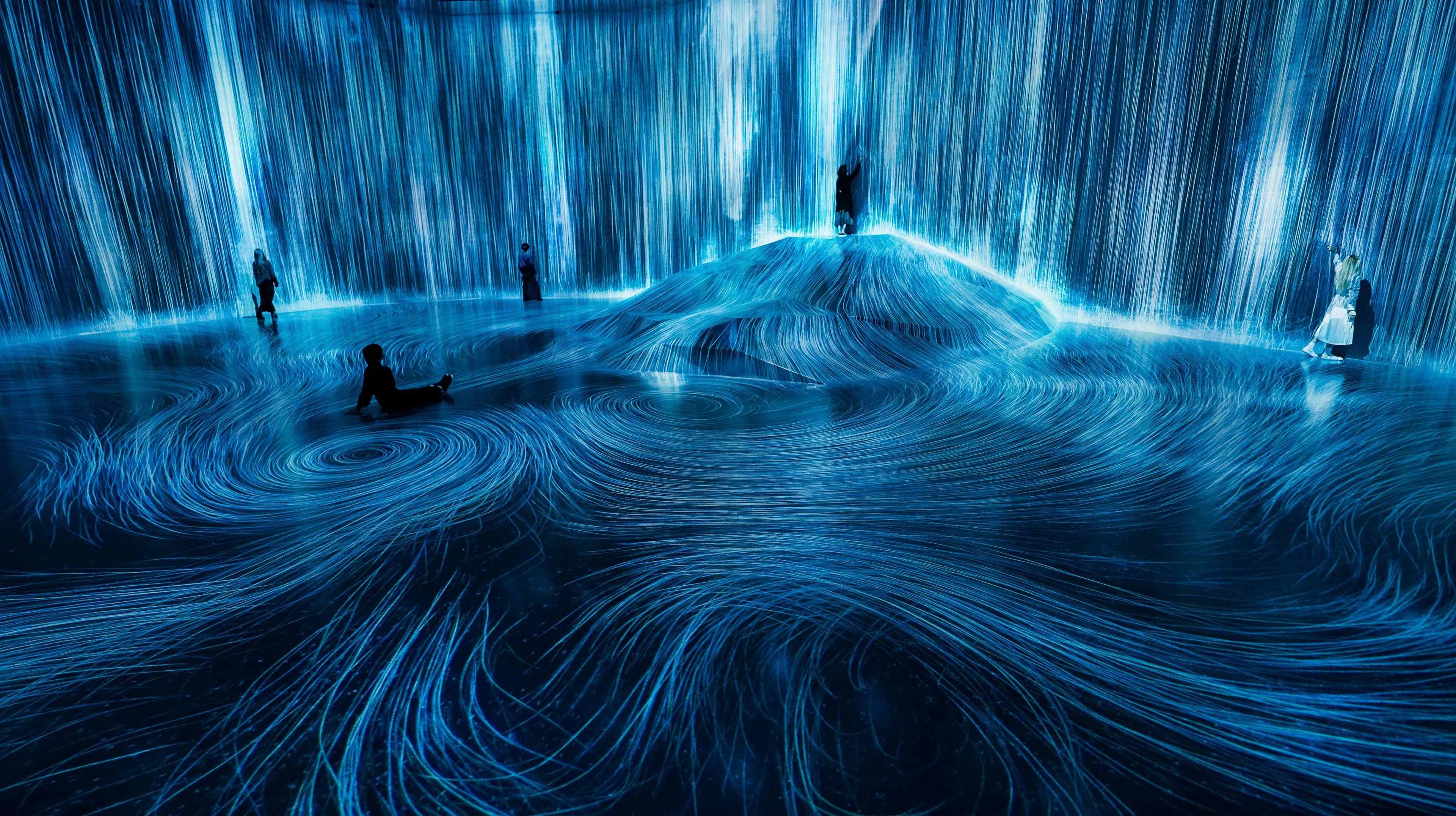 在人们聚集的岩石上，注入水粒子的世界 / Universe of Water Particles on a Rock where People ...