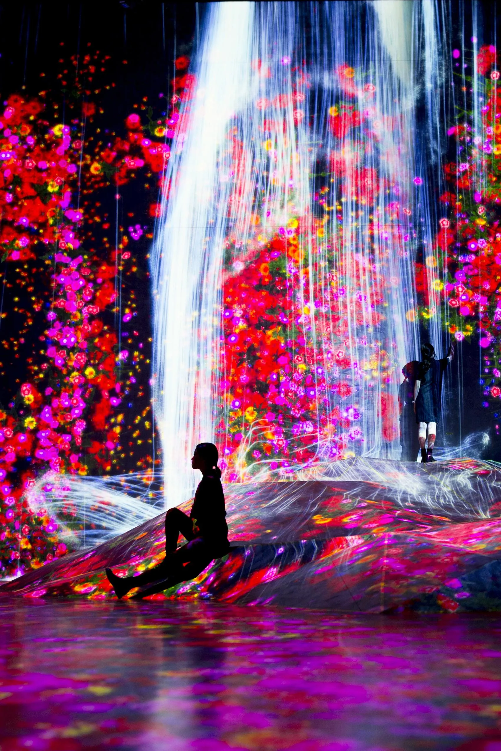 在人们聚集的岩石上，注入水粒子的世界 / Universe of Water Particles on a Rock where People ...